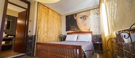A bedroom with a wooden bed, a large wall mural, a bathroom with a tiled shower, and a circular ceiling light.