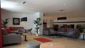 A modern interior with sofas, chairs, and tables arranged in a spacious area. - Hotel Asgard (Gersthofen)