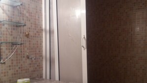 Un baño con lavamanos blanco, cabina de ducha de vidrio y un inodoro.