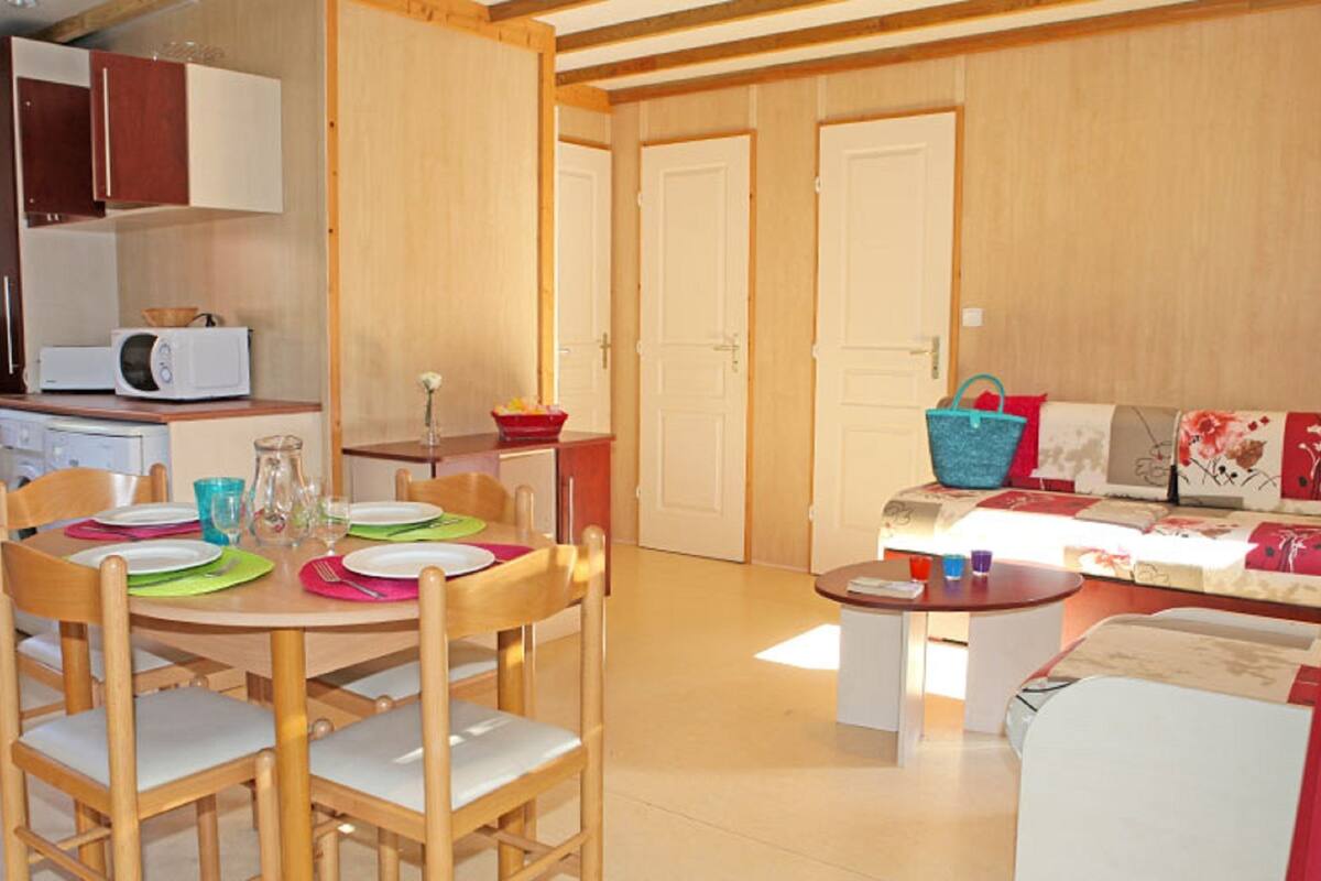A compact living space with a dining area, kitchenette, and a sofa set.