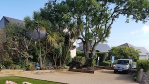 A residential driveway with a gravel path, a white van parked on the side, and a wooden fence. - Count House Cottage B&B - Adults Only (St Ives)
