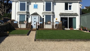 A two-story house with a blue door, a sign indicating it is a 'Count House Cottage', and a small front garden with a gravel path. - Count House Cottage B&B - Adults Only (St Ives)