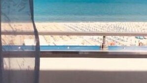 A beach view from a window with a view of the sea and sand. - Hotel Oriente (Cervia)