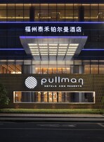 Un hotel con fachada moderna, amplias ventanas y un cartel llamativo de Pullman Hotels and Resorts.