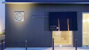 Un edificio moderno con una entrada amplia, un letrero que indica un dormitorio y un logotipo en la pared.