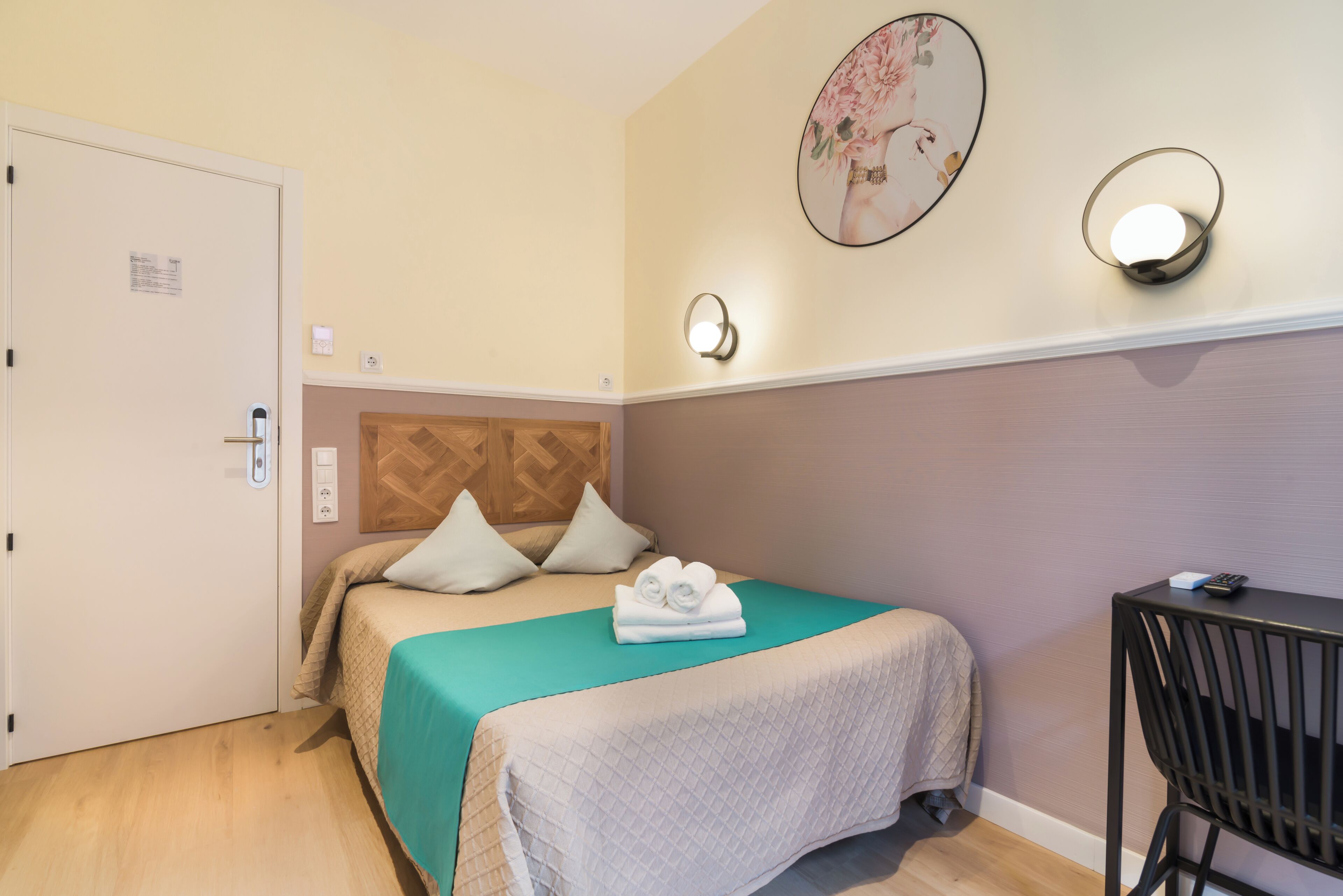 Une chambre d’hôtel avec un lit, un bureau et une chaise.
