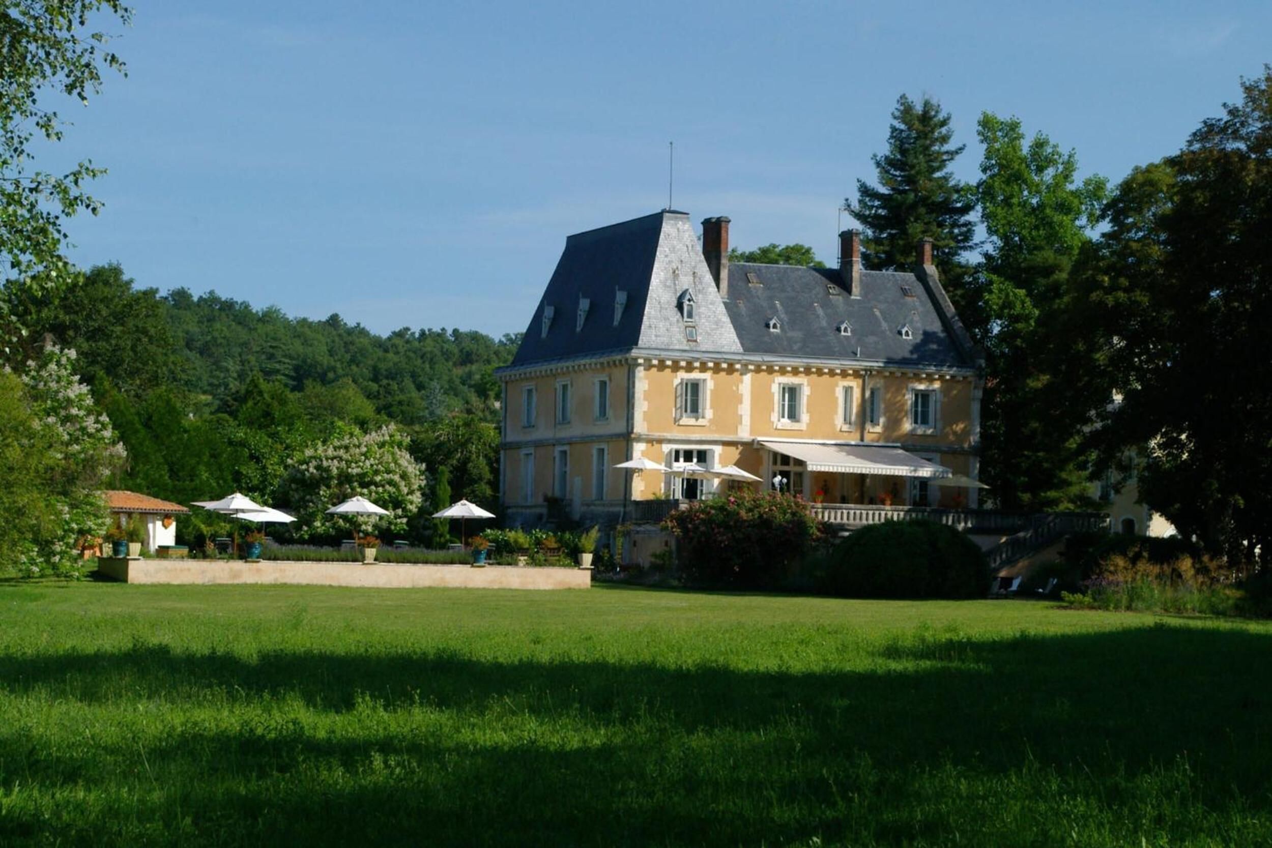 A large, two-story building with a prominent gabled roof and a balcony.