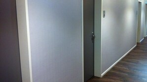 A hallway with grey walls and wooden flooring, leading to multiple doors. - Hotel Hansehus Süd (Hamburg)