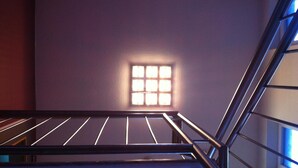 A modern interior with a staircase, a small window with natural light, and a metal railing. - Hotel Hansehus Süd (Hamburg)