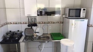 Cocina compacta con estufa, pileta, microondas y licuadora.