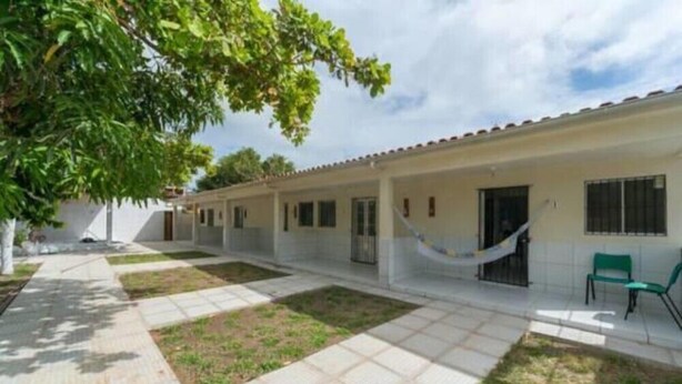 Un edificio con un patio empedrado, una hamaca y un banco.
