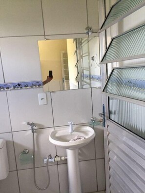 Ein Badezimmer mit Waschbecken, Spiegel und Dusche.
