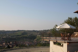 A terrace with outdoor furniture and a view of a town. - CasaMatilda Agriturismo Langhe (Dogliani)