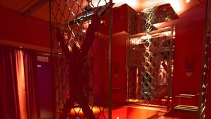 Une pièce éclairée de lumière rouge, avec un canapé, une table basse en bois et un élément de séparation décoratif.