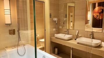 A modern bathroom with a glass-enclosed shower, two sinks, and a large mirror.