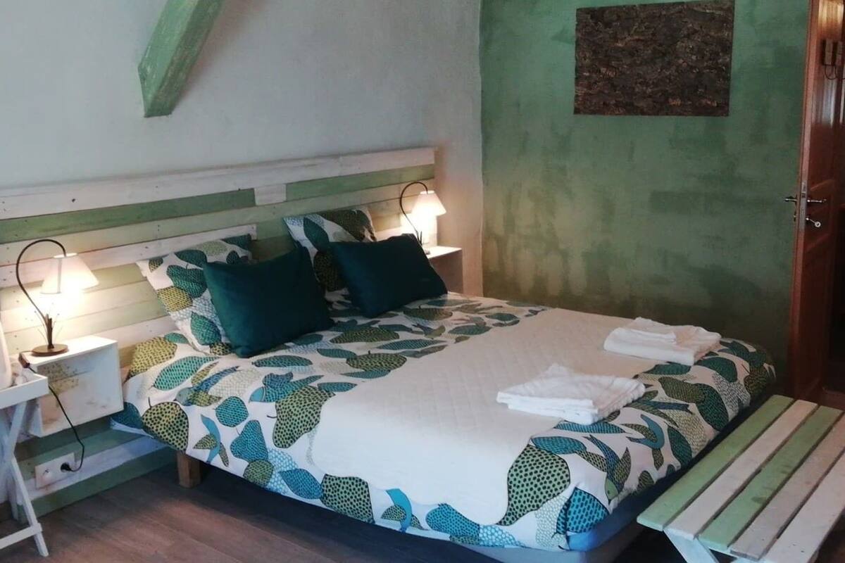 A bedroom with a bed, bedside tables, and a nightstand.