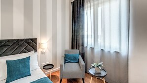 A hotel room with a bed, a chair, a small table with a plant, and a window with curtains. - Napoli Great View B&B (Naples)