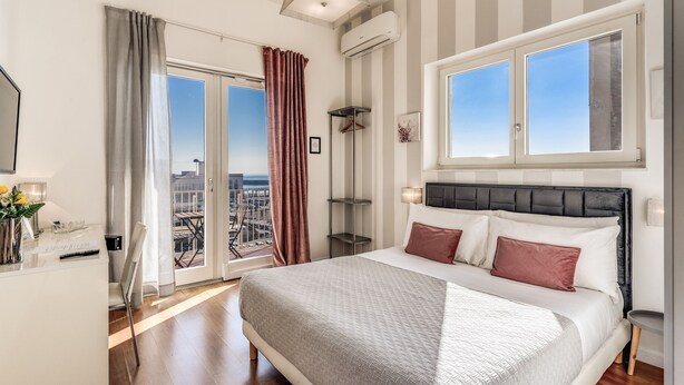 A modern bedroom with a large bed, striped walls, and a city view. - Napoli Great View B&B (Naples)