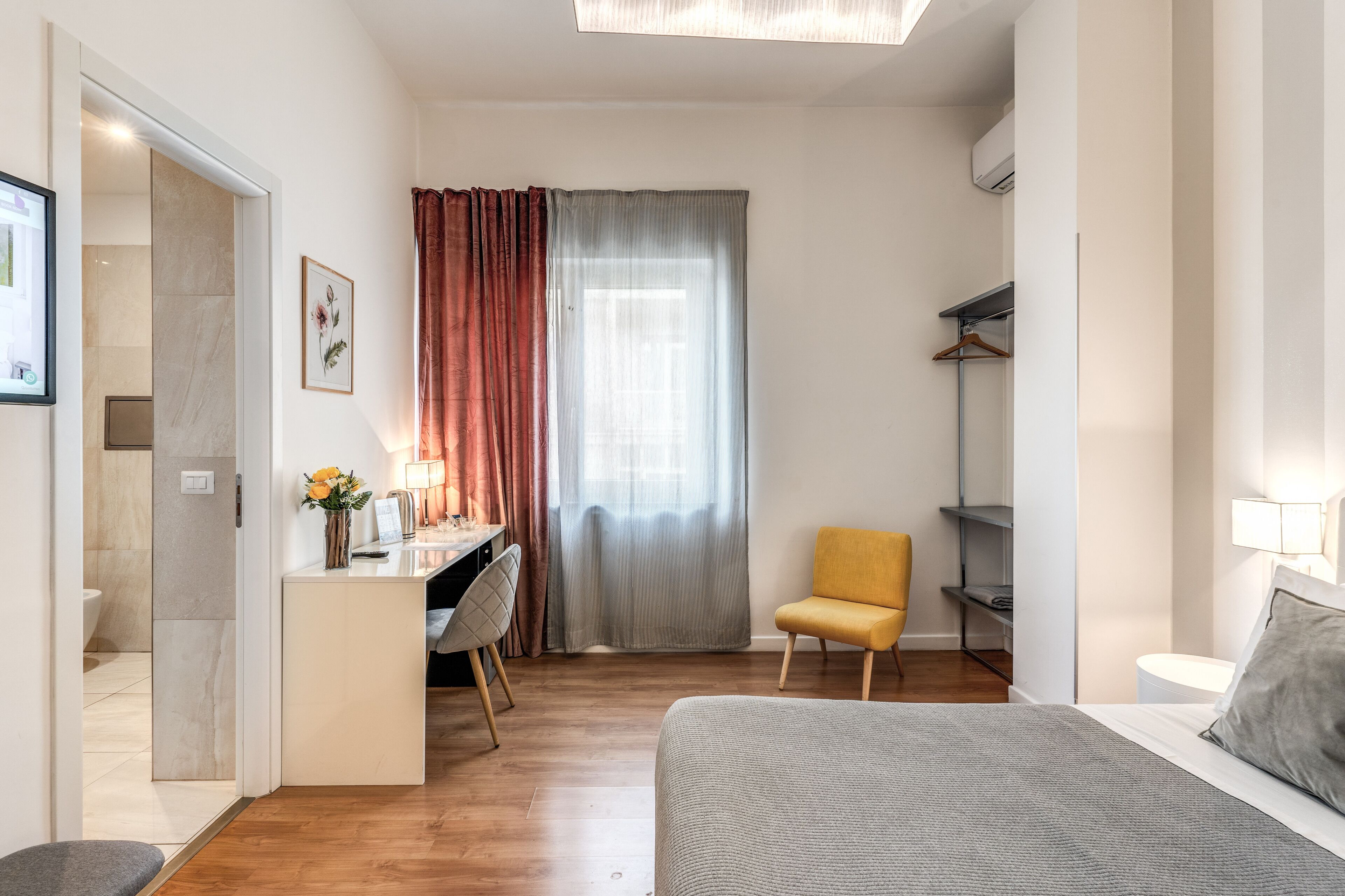 Un dormitorio moderno con cama, escritorio, silla y armario.