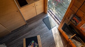 Una cocina compacta con armarios de madera, un fregadero y un pequeño comedor con mesa y sillas.