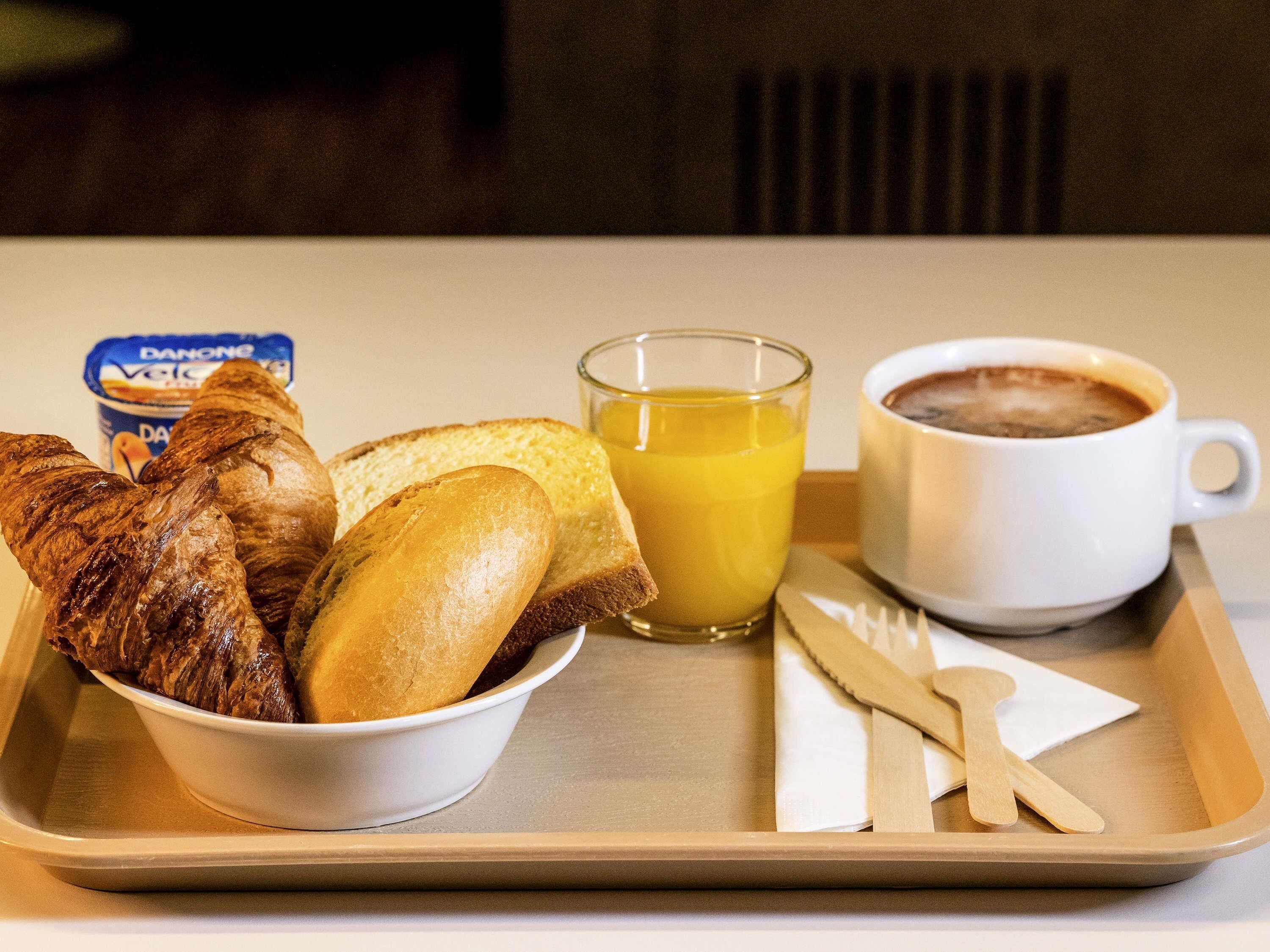 A tray with croissants, a glass of orange juice, and a cup of coffee.