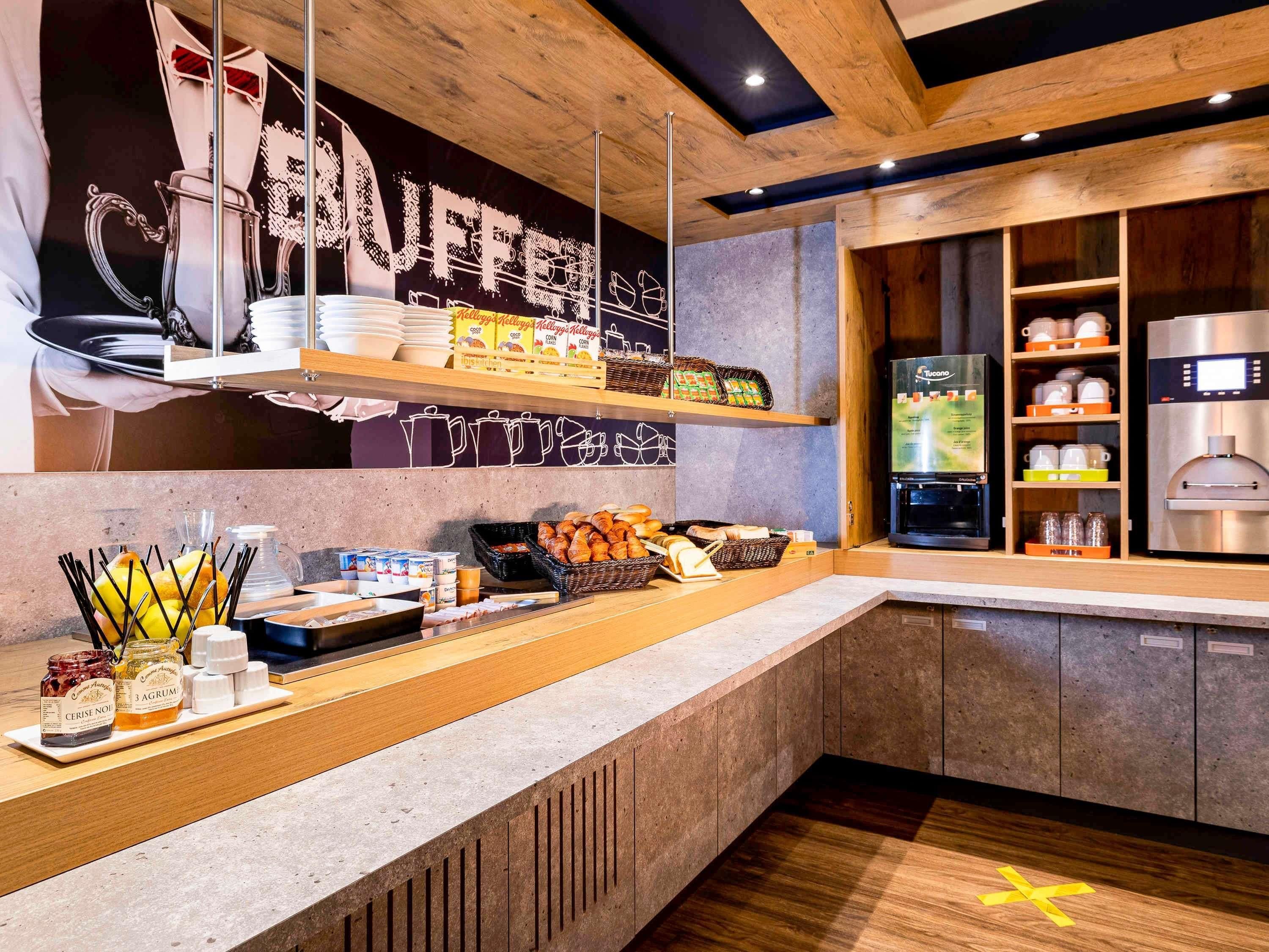 Un espace buffet proposant une variété de plats, une machine à café et un réfrigérateur.