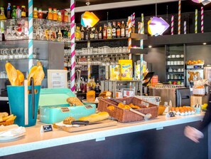 A bakery counter with bread, pastries, and a variety of beverages.