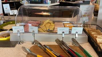 A buffet with various food items and utensils.
