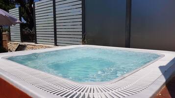 Een buitenzwembad, parasols voor strand/zwembad