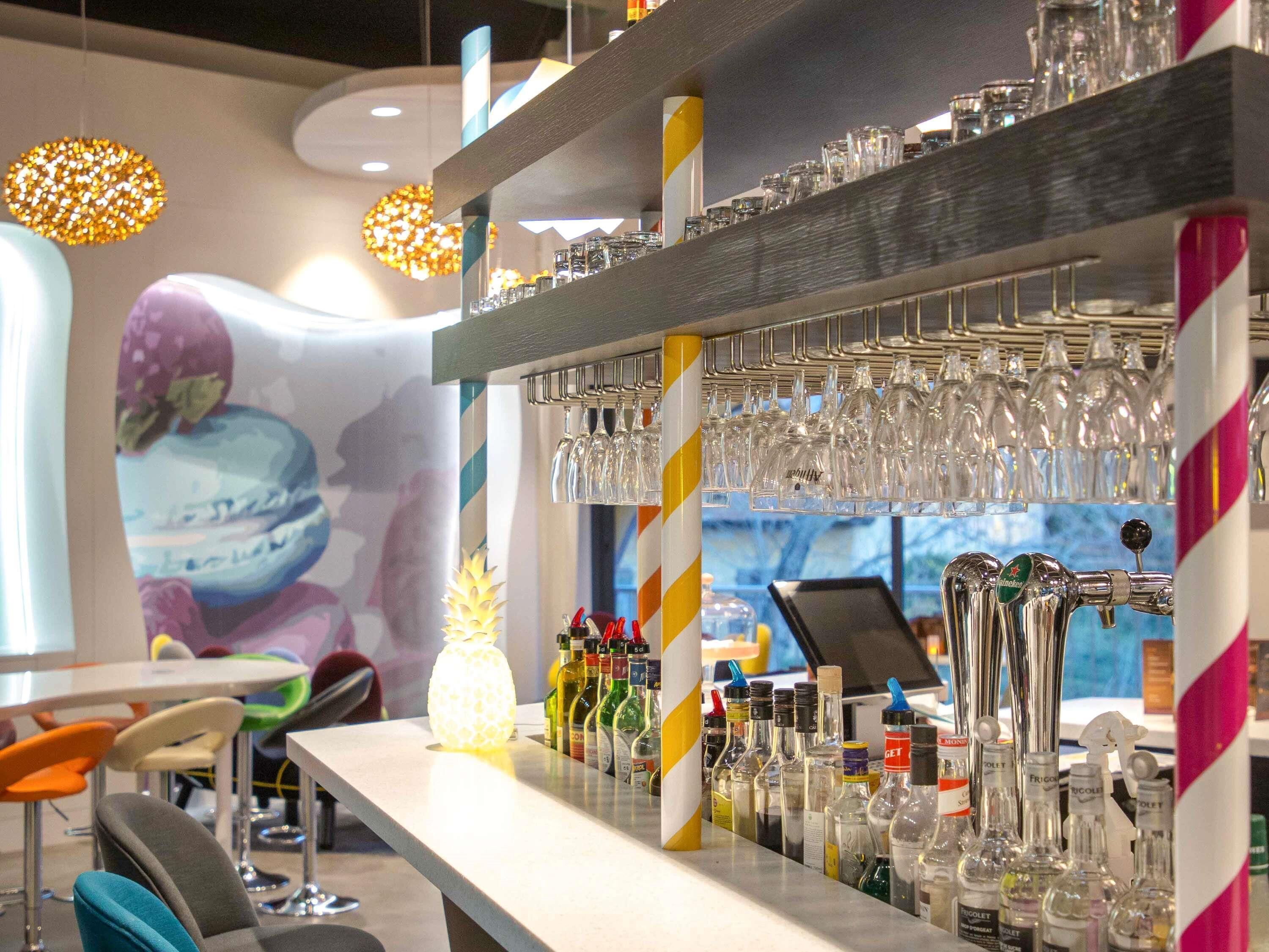 A bar area with multiple taps, glasses, and bottles.