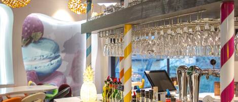 A bar area with multiple taps, glasses, and bottles.