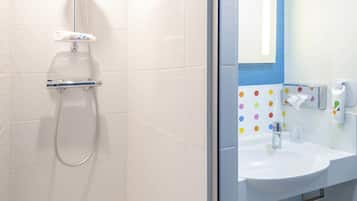 A bathroom with a shower, a sink, and a mirror.