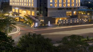 Een modern hotel met een opvallend 'NOVOTEL'-bord, met een symmetrische gevel en gelijkmatig verdeelde ramen, plus een centrale ingang.