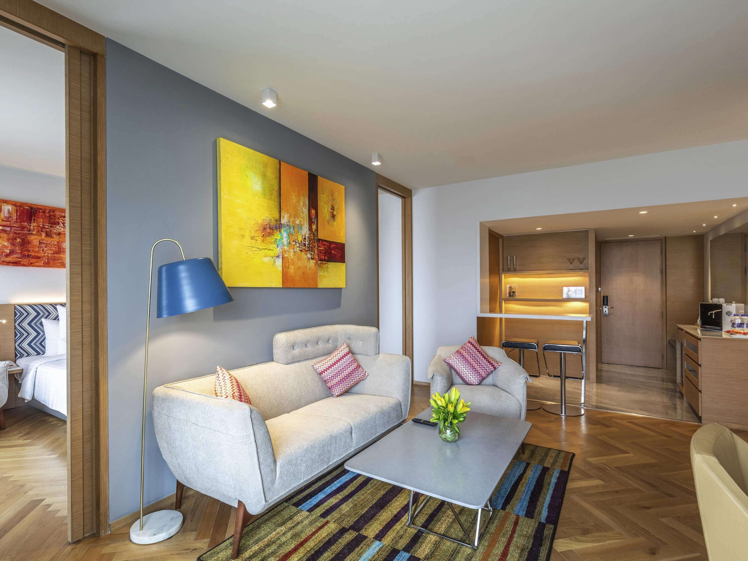 Ein modernes Wohnzimmer mit einer Couch, einem Couchtisch und einem Gemälde an der Wand.