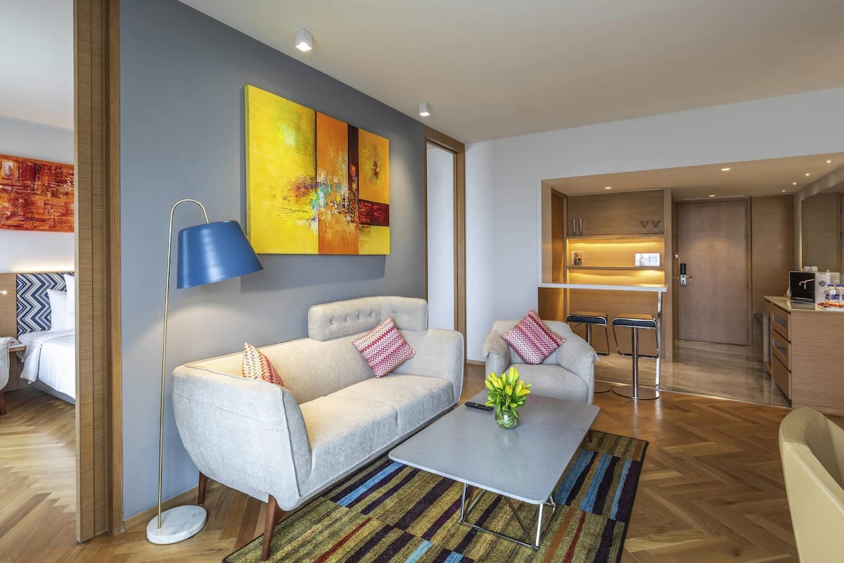 A modern living room with a sofa, coffee table, and a painting on the wall.