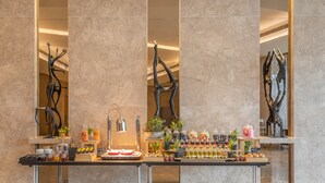 Ein Frühstücksbuffet mit einer Auswahl an Speisen und Getränken, darunter Gebäck, Früchte und Erfrischungen.