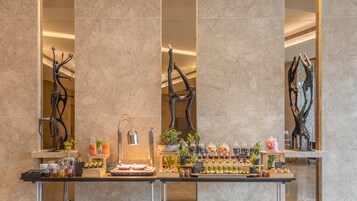 Ein Frühstücksbuffet mit einer Auswahl an Speisen und Getränken, darunter Gebäck, Früchte und Erfrischungen.