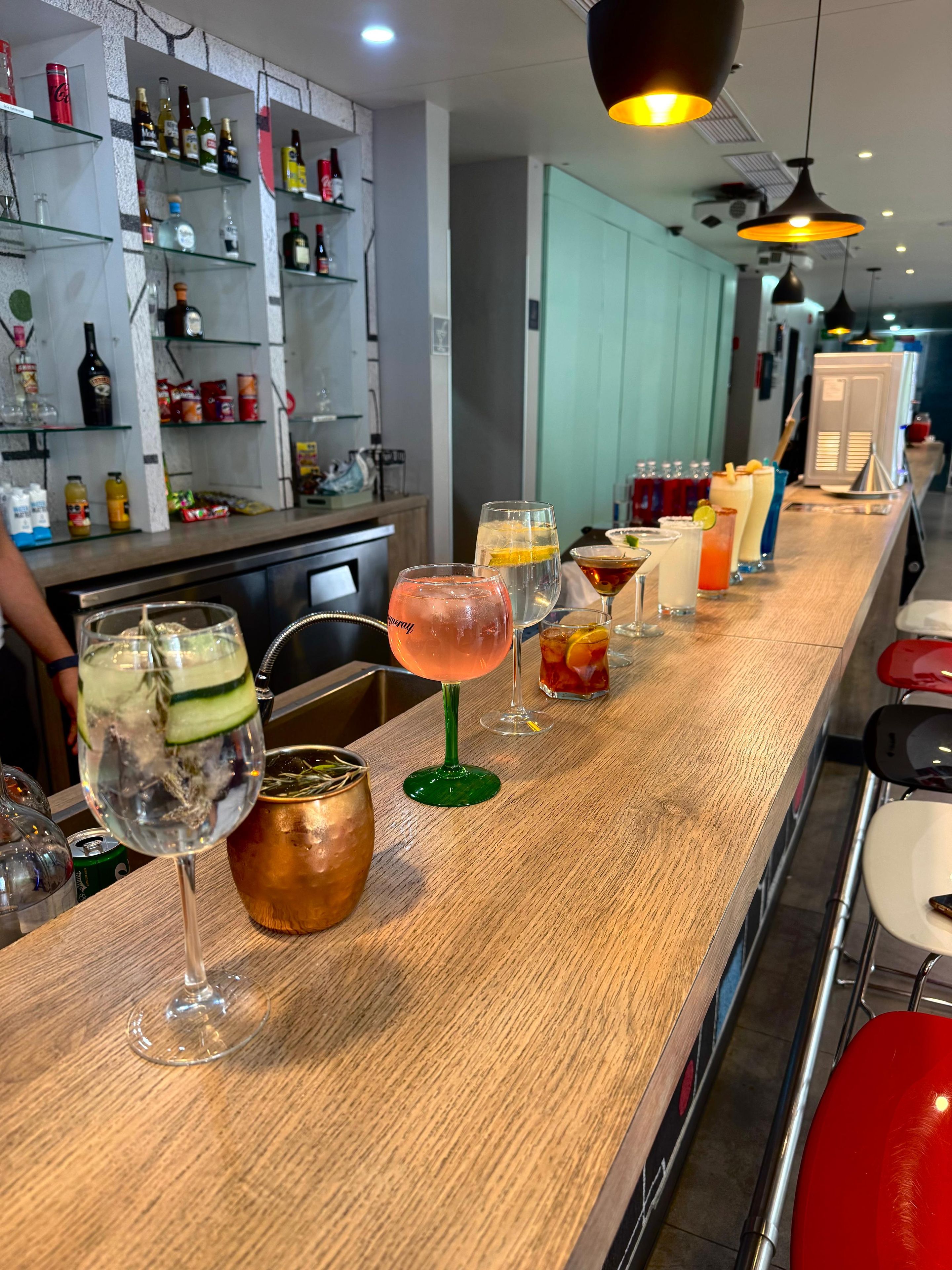 A bar area with a variety of drinks and bottles on shelves.