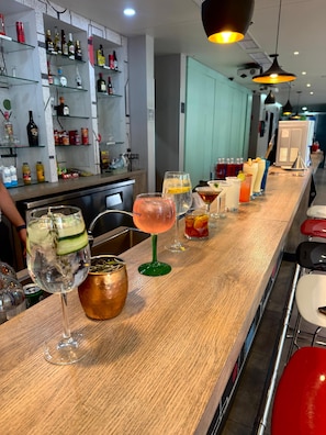 Een bar met verschillende drankjes en flessen op planken.