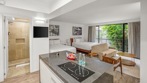 A modern hotel room with a kitchenette, a bed, a sofa, and a balcony with a view. - Armonik Suites (Mexico City)
