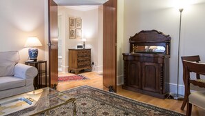 A living room with a sofa, coffee table, and a wooden cabinet with a mirror.