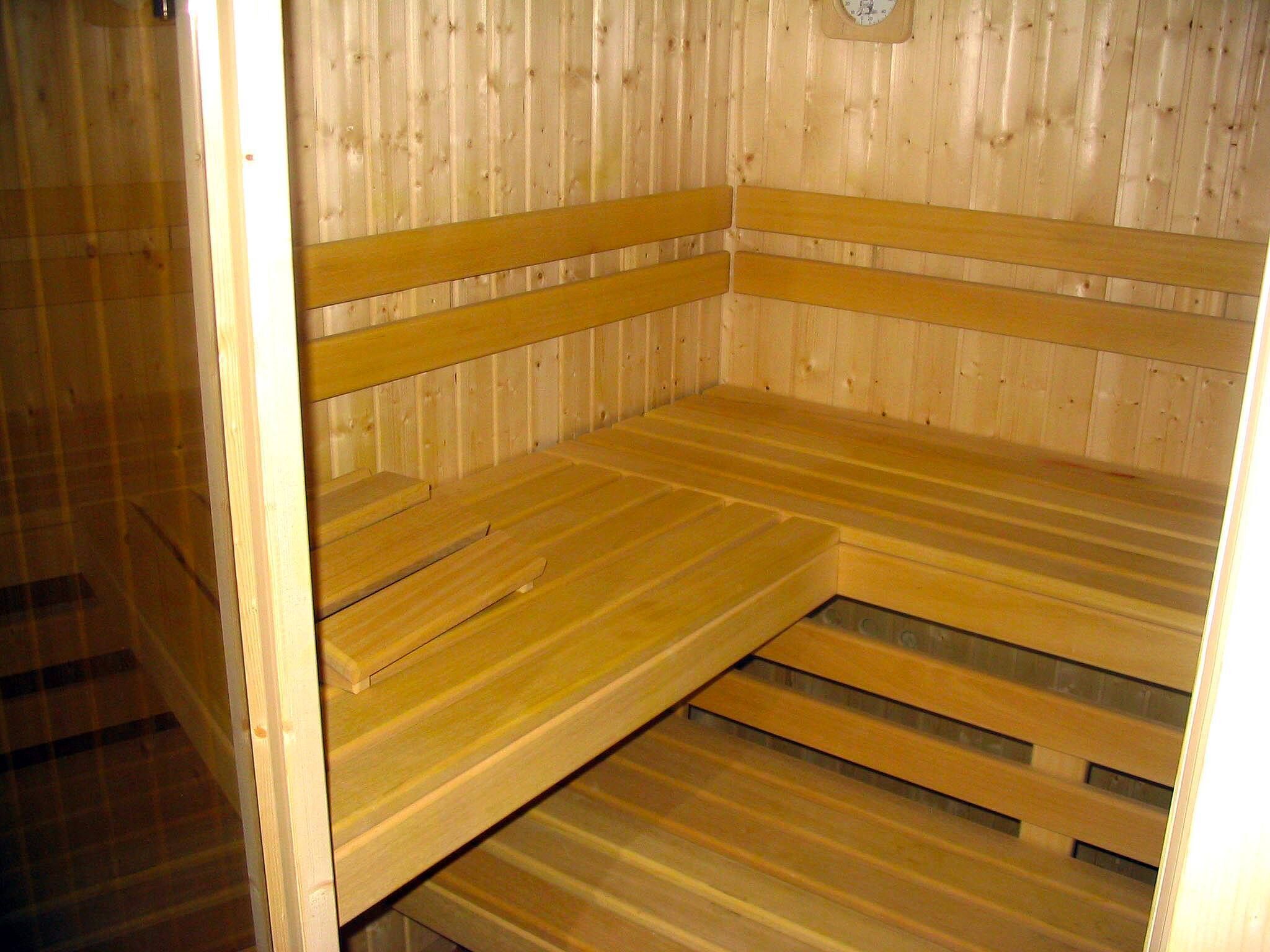 A sauna with wooden benches and a sloped floor.
