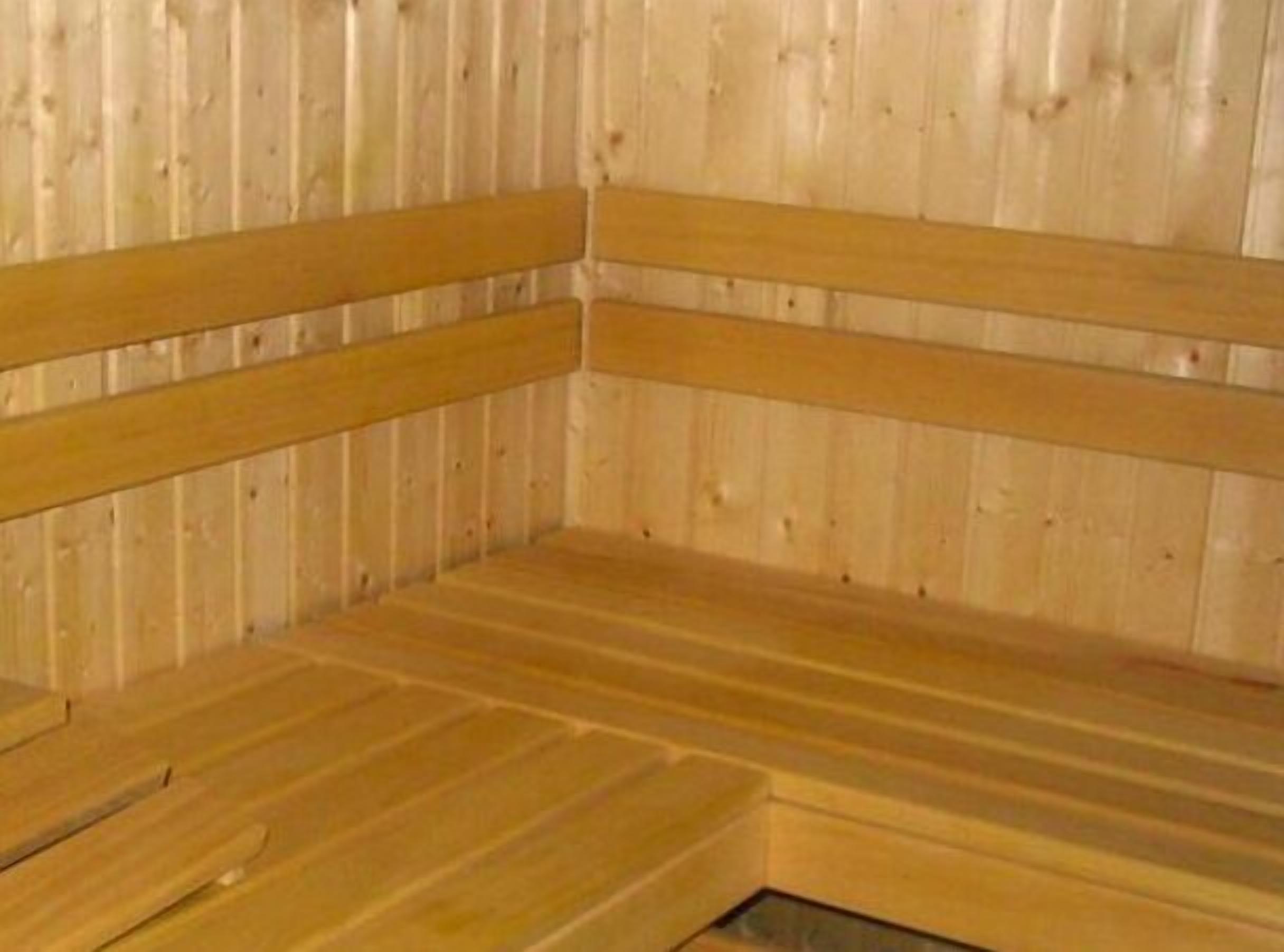 Una sauna con bancos y paredes de madera.