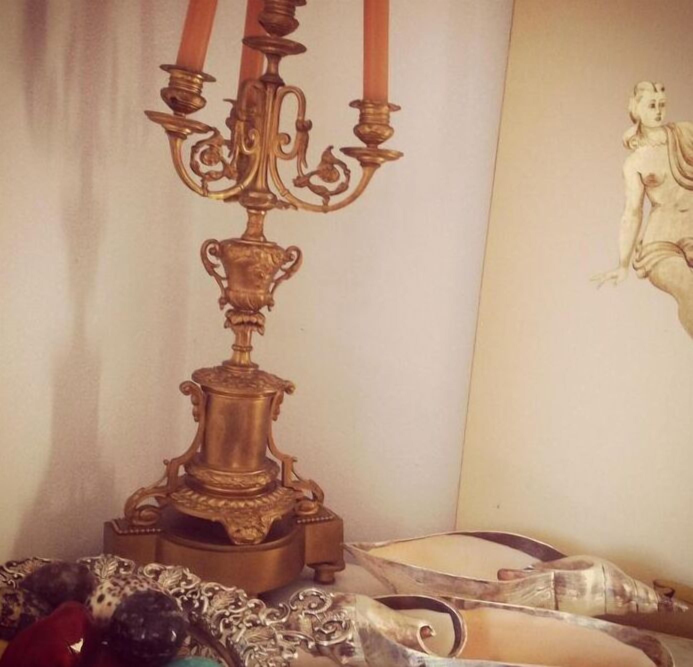 Quarto com um candelabro decorativo, uma obra de arte emoldurada e um tapete estampado.