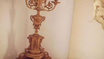 Quarto com um candelabro decorativo, uma obra de arte emoldurada e um tapete estampado.