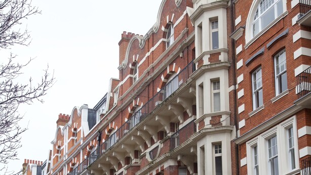 A row of red brick buildings with white trim and multiple balconies. - A Place Like Home - Inviting Flat near South Kensington (London)
