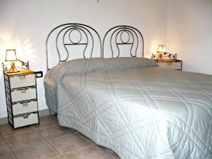 A bed with a quilted white duvet, two bedside tables with lamps, and a metal headboard. - Agriturismo Tenuta del Morige (Galatone)