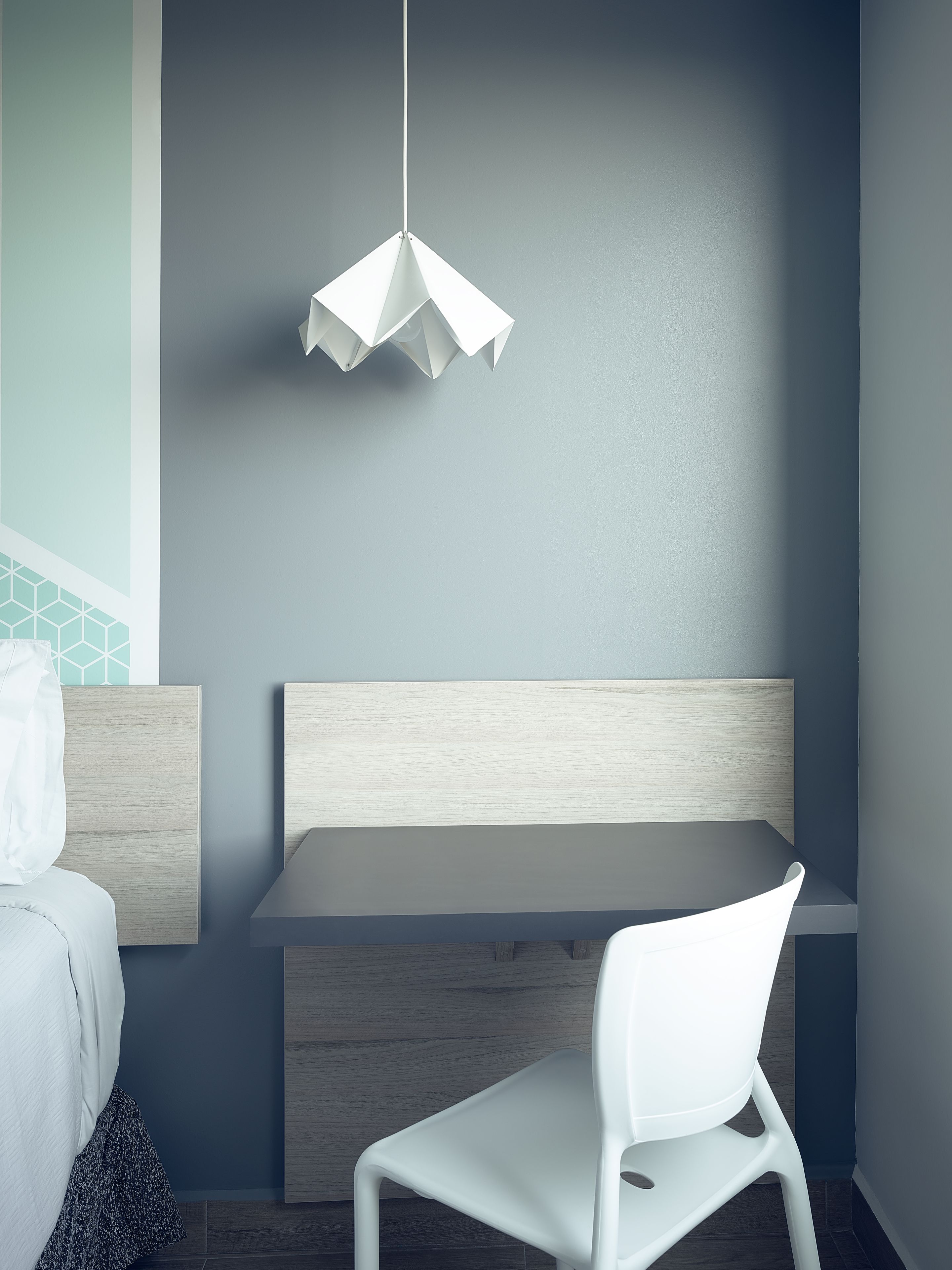 Una habitación moderna con una cama, un escritorio y una silla.