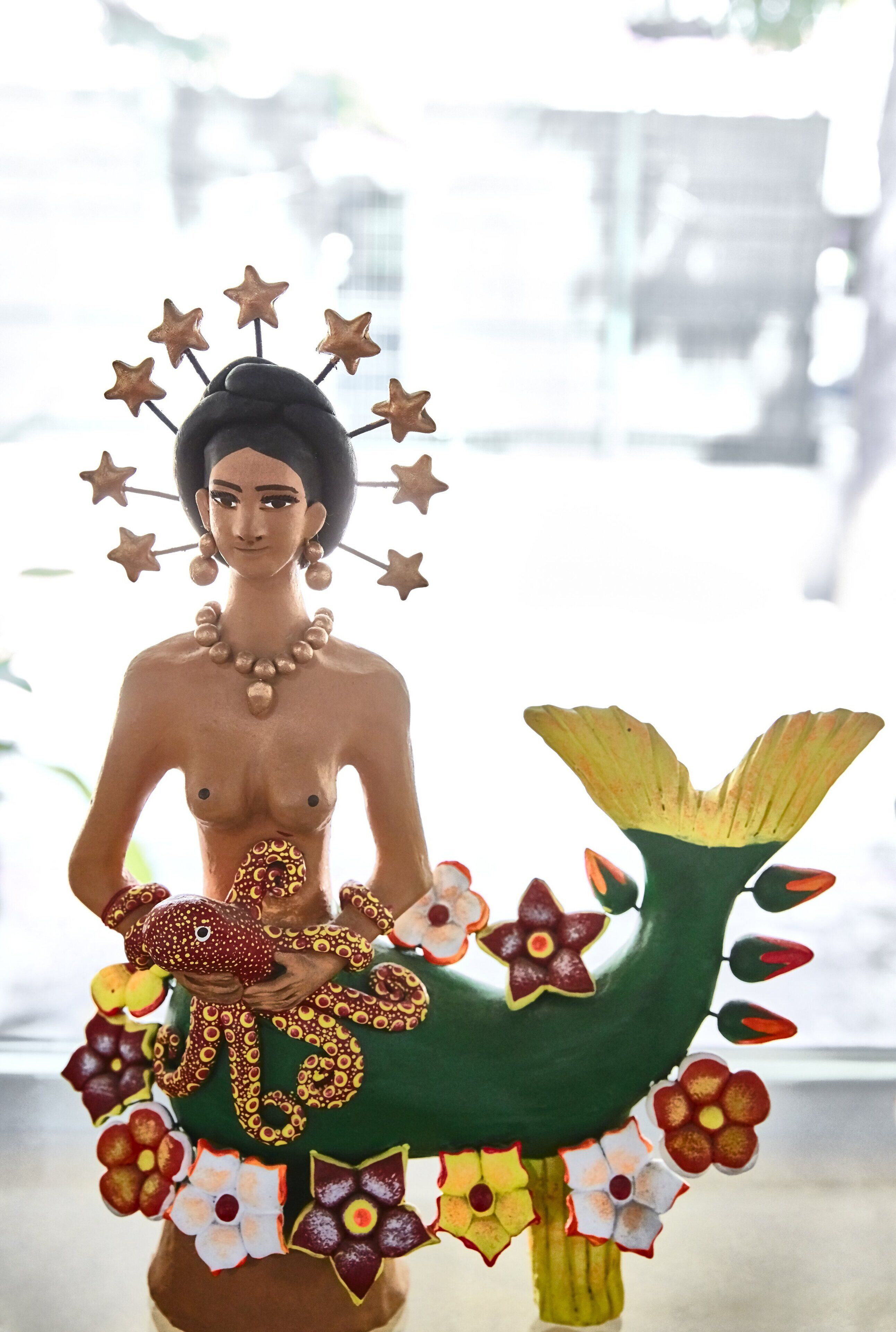 A statue with a mermaid tail and a monkey.