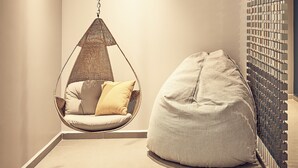 A room with a hanging chair, a bean bag, and a wall-mounted rack. - One Acapulco Diamante (Acapulco)